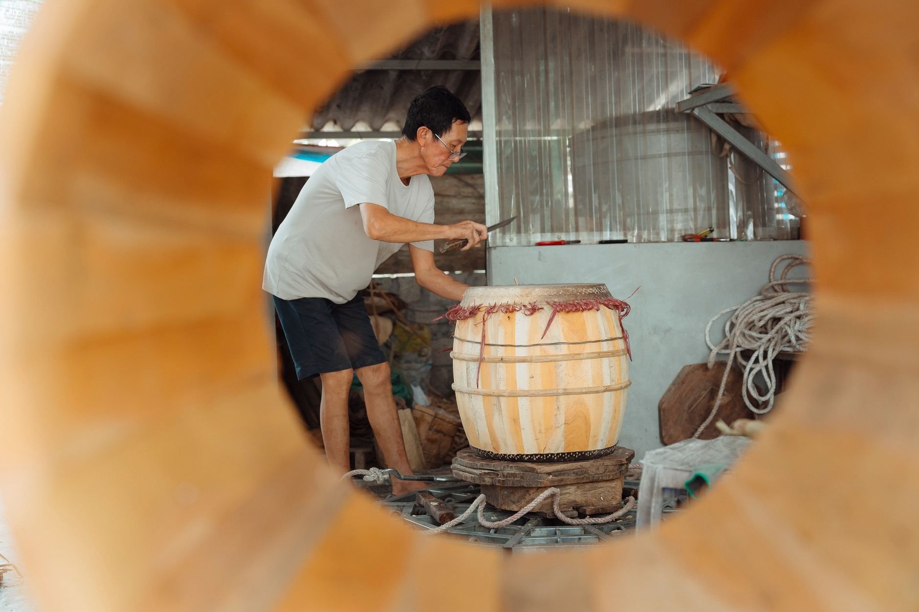 A skilled craftsman shapes a wooden piece in an artisan workshop